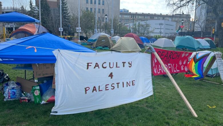 Tents and signs are set up outside a university.