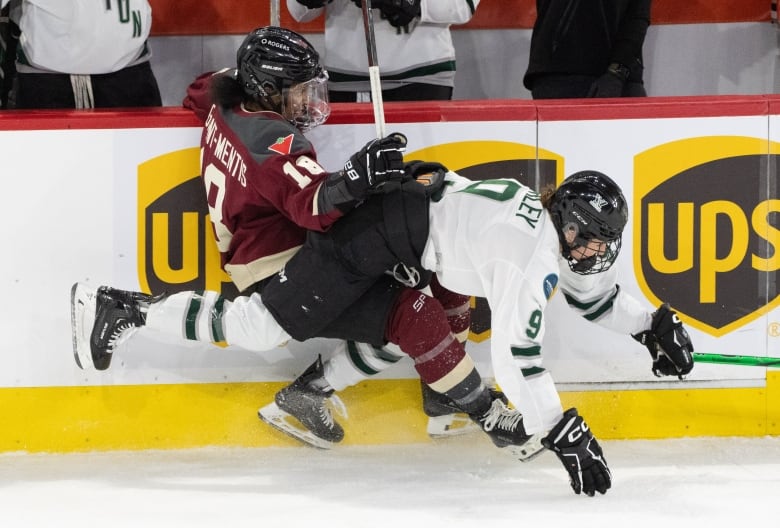 Two female PWHL hockey players battle on the boards during second period PWHL playoff hockey action in Laval, Que., on Saturday, May 11, 2024.