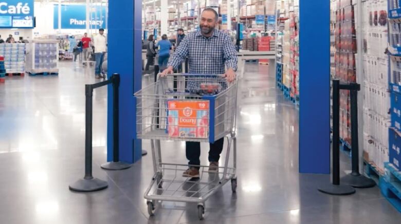 A man pushing a shopping cart through an exit at Walmart.