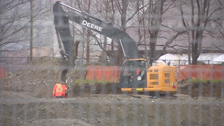 An excavator digs on a construction site.