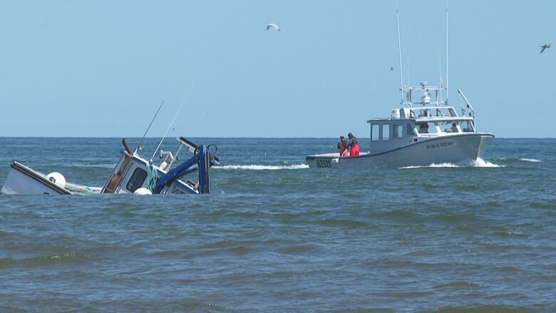 Fishing boat navigating around sunken boat.