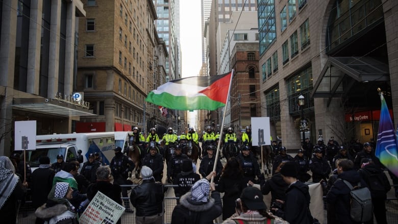 Protesters for Gaza gather outside a downtown hotel in Toronto, the planned location of an event for Prime Minister Justin Trudeau, on Friday, Mar. 15, 2024.