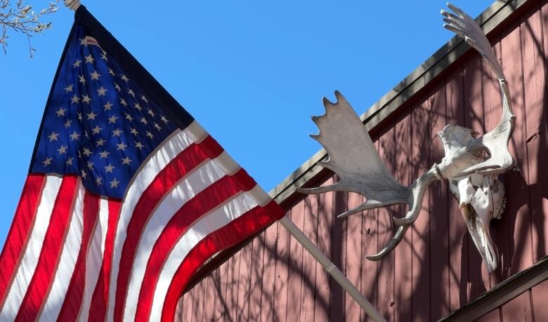 A U.S. flag and some moose antlers adorn one of the storefronts in downtown Waterton. 