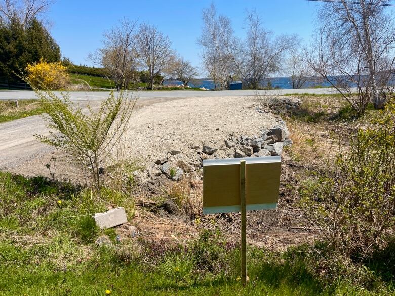 A patch of gravel-covered earth lies at the corner of two roads.