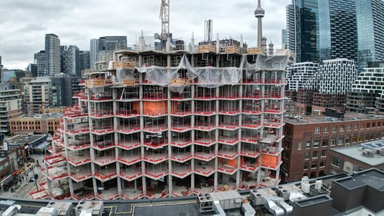 Aerial view of condominium under construction with CN Tower and Toronto skyline in the background. 