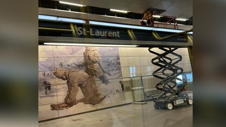 A worker looks at the ceiling tiles at a train platform.