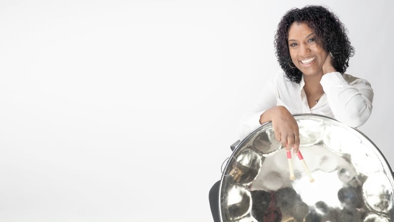 A portrait of a woman with a steelpan. 