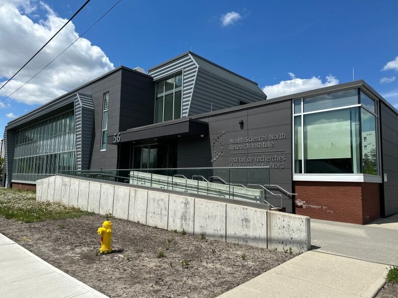 A modern grey building with a sign that says Health Sciences North Research Institute.