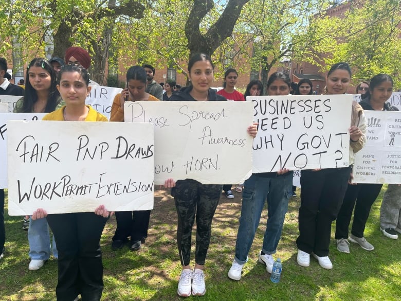 Around 150 newcomers stood silently outside the Coles Building in Charlottetown on Thursday during a legislative standing committee meeting about the P.E.I. government's changes to its immigration policies.