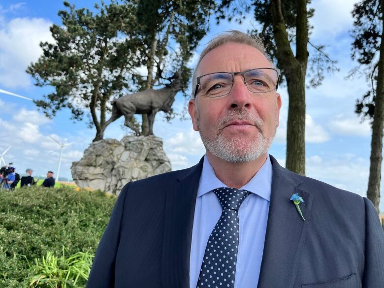 steve crocker poses in front of a caribou statue in northern france.