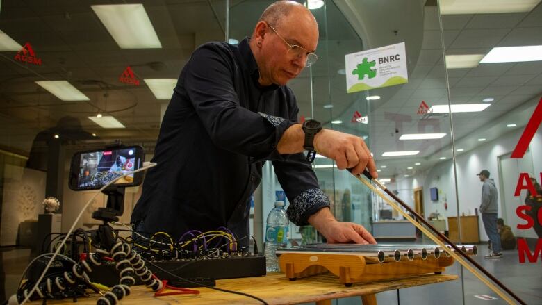 A man plays an electronic instrument.