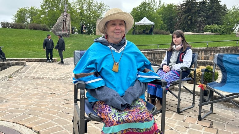 A woman sits in a chair.