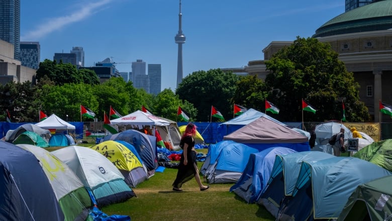 A woman walks between the tents in the pro-Palestinian encampment set up at the University of Toronto campus on May 26, 2024.