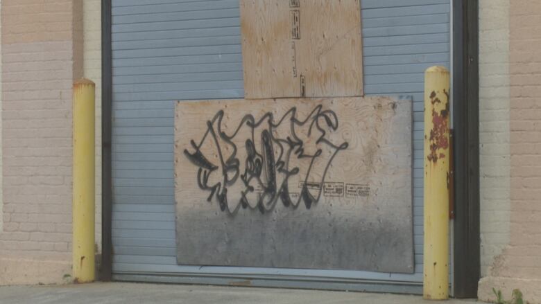 Graffiti on a boarded-up entrance to an arena.