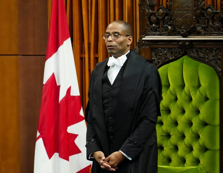 A man in black robes stands in the House of Commons.