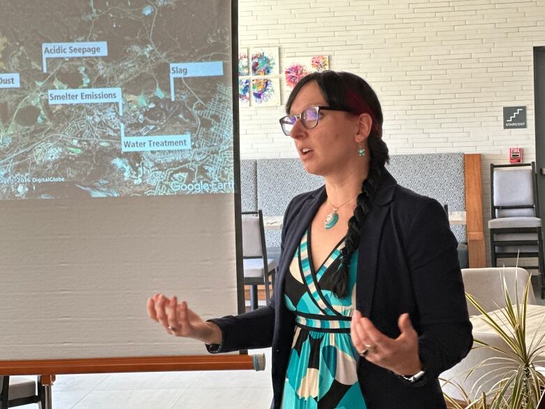 A woman with dark hair giving a presentation.