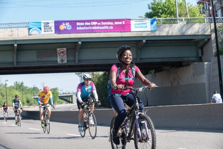 People cycle on a highway.