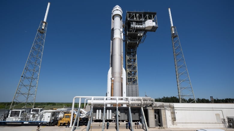 A rocket stands against a blue sky.