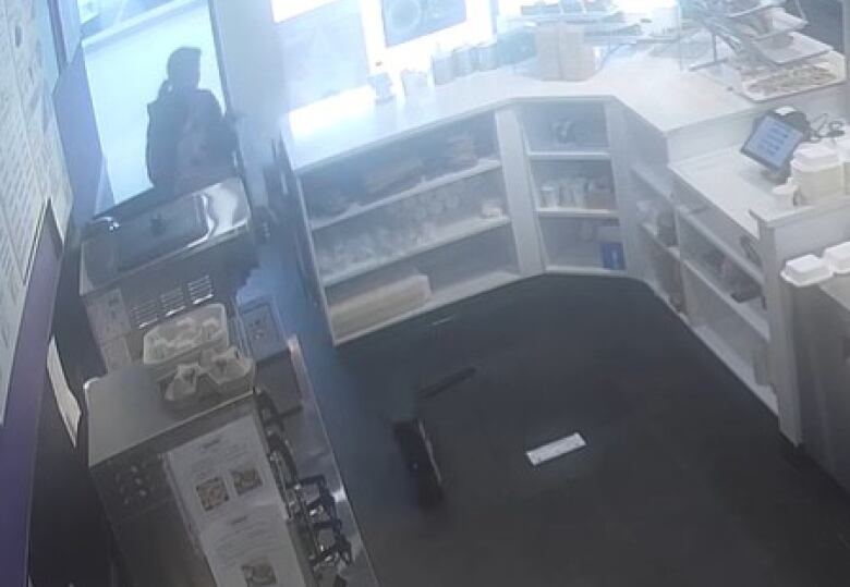 A surveillance video still shows a restaurant counter area