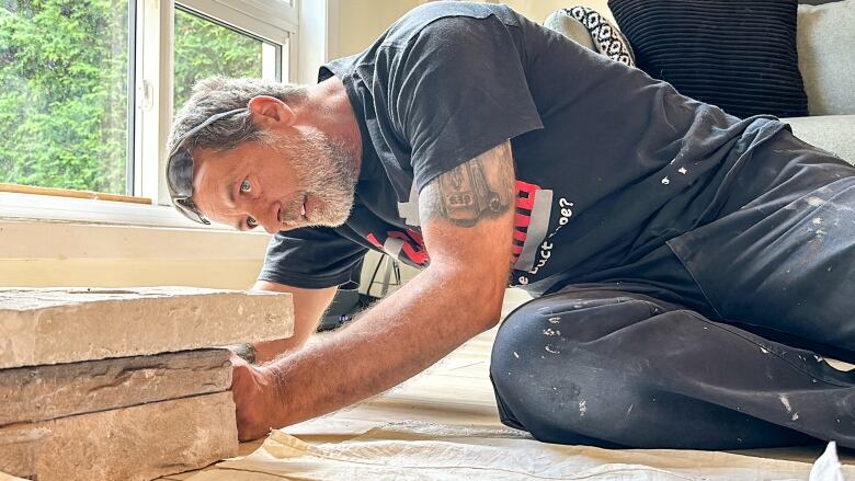 Jorg Santowski adds some some finishing stonework to a rental property  