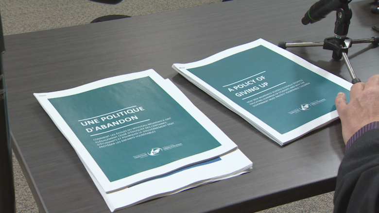 A physical copy of a report, one in French and one in English, on a desk.