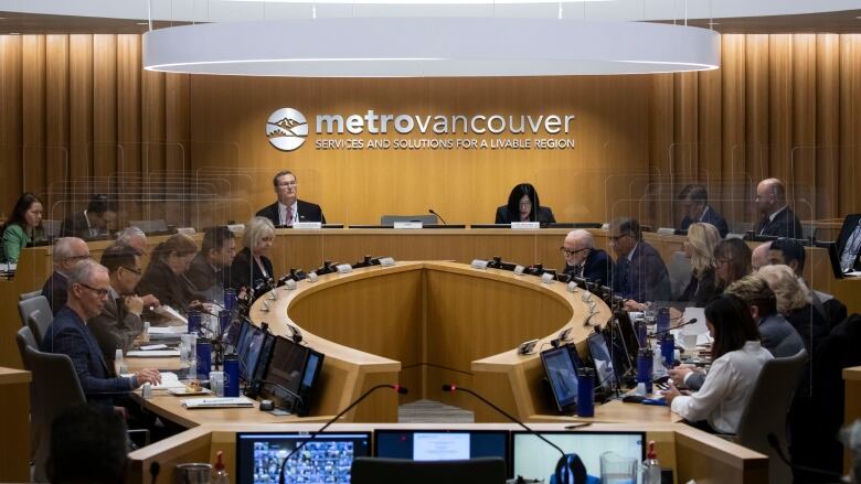 people sit at desks in a large meeting room