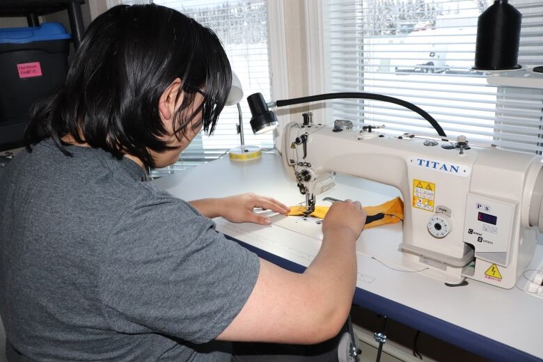 A person works at a sewing machine.