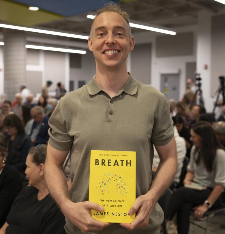 Chris Eddy holds a copy of Breath by James Nestor.