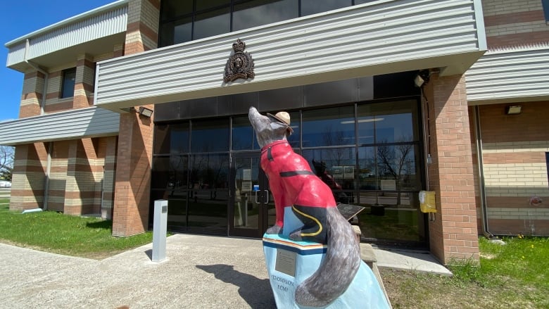 a building with a statue of a wolf in rcmp gear outside.