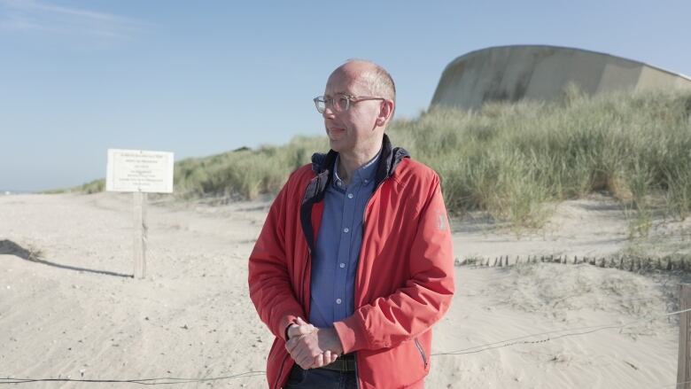 A man stands on a beach.