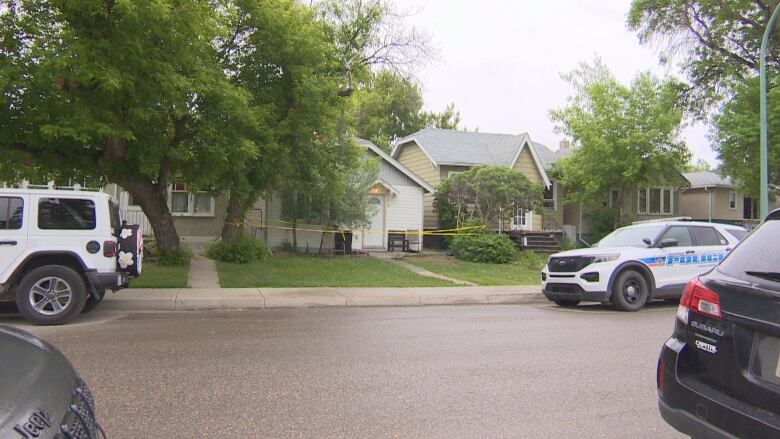 Regina police car in front of a house with police tape blocking off the entrance