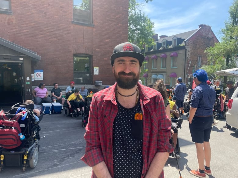 A person smiling in front of a building