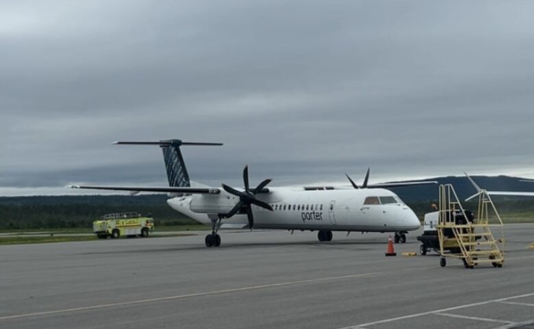 A De Havilland Dash 8-400 airplane sits on a runway.