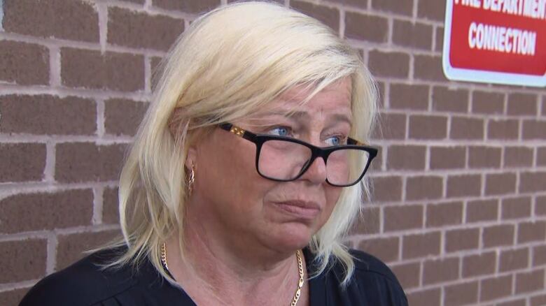 Heather Parkes, wife of homicide victim Delroy 'George' Parkes, 61, speaks to reporters outside of North Albion Collegiate Institute, a high school in Etobicoke, on Tuesday. Her husband died in hospital on Sunday after a mass shooting in the school's parking lot.