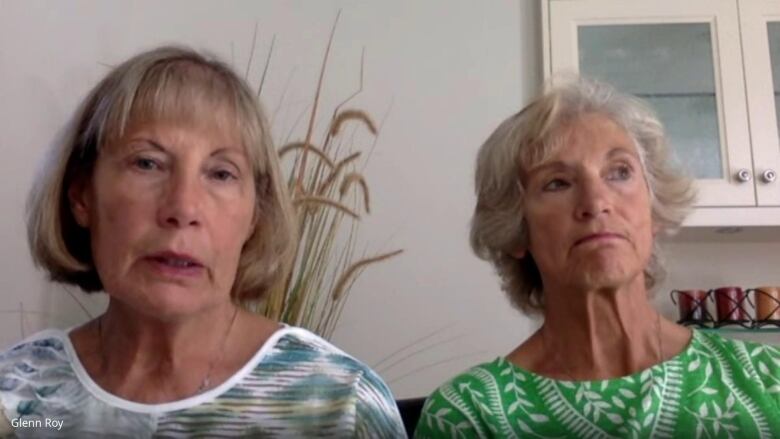 Two older white women speak in a kitchen.