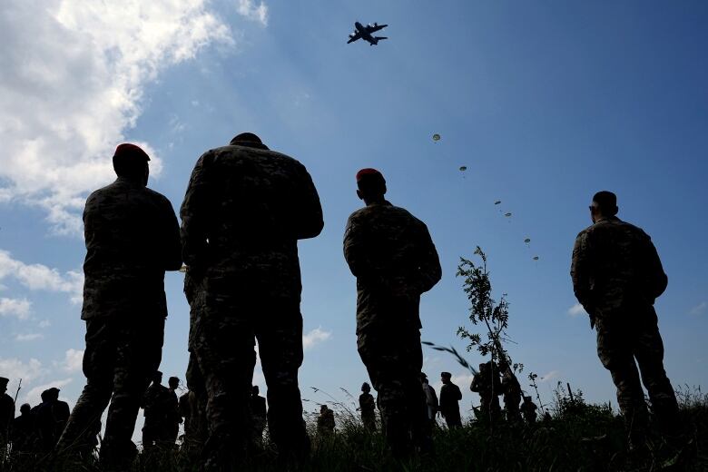 Spectators attend a multinational parachute drop as some 400 Canadian, British, Belgian and U.S. paratroopers jump to commemorate the contribution of airborne forces on D-Day. The drop was part of events marking the 80th anniversary of D-Day in Sannerville, Normandy, France on Wednesday, June 5, 2024.