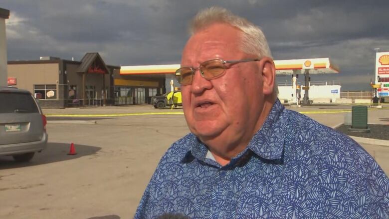 A man in front of a gas station.