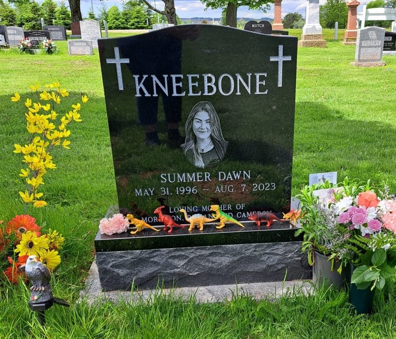 A gravestone for Summer Dawn Kneebone, surrounded by flowers. 