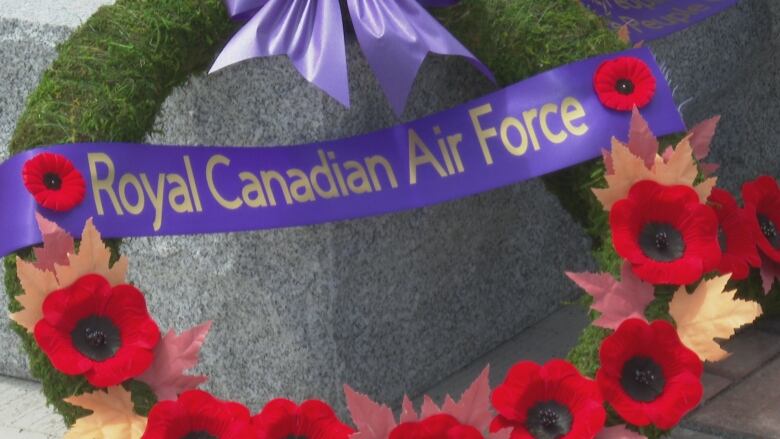 A wreath of red poppies with a purple banner.