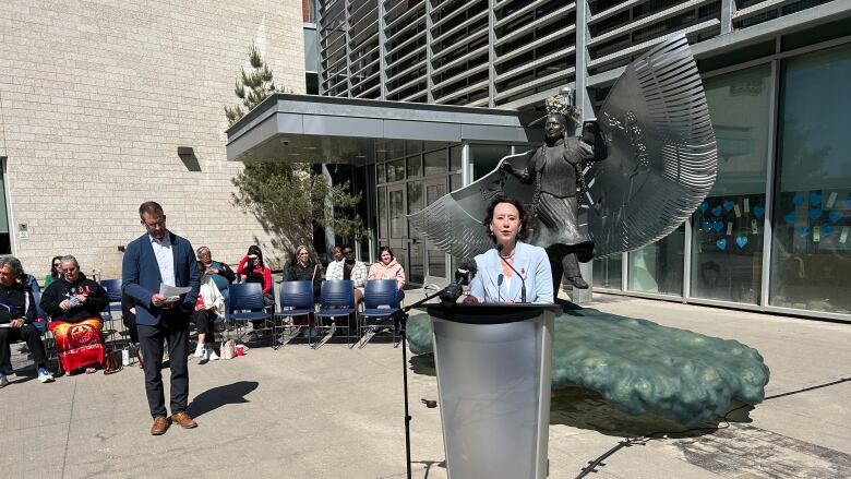 A woman stands at a podium.