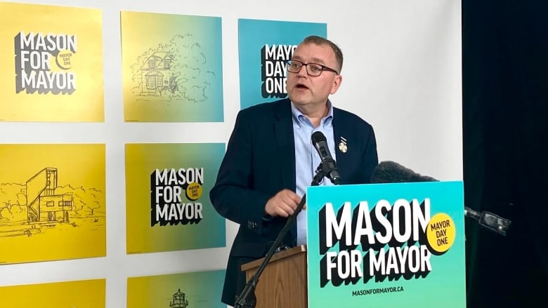 A man wearing a suit stands at a podium.