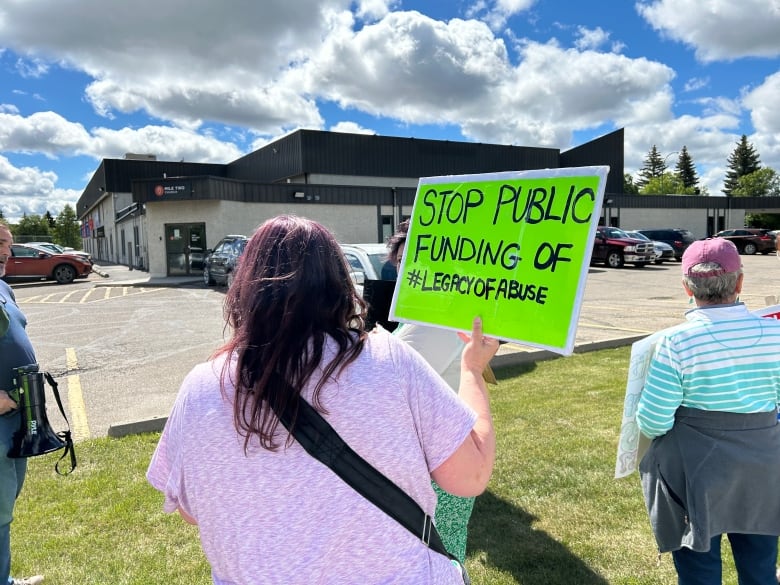 A woman holding a poster.