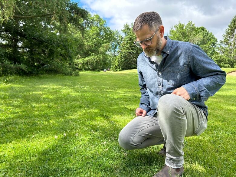 man looking at grass