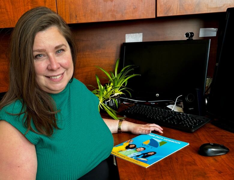 A smiling woman sitting at a desk