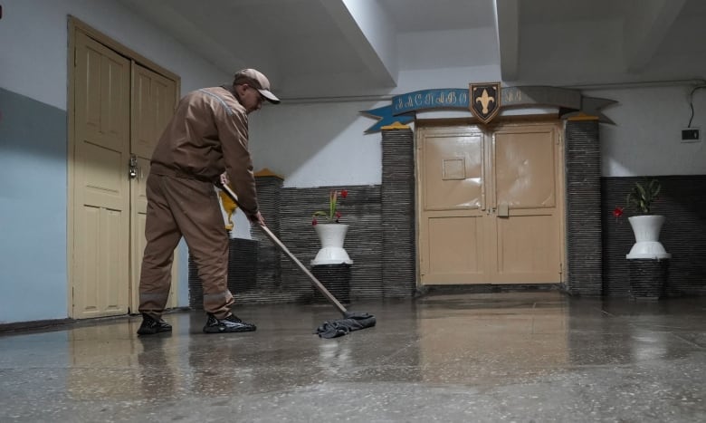  Renat Temirgaliev mops a hallway at a penal colony near Kyiv on June 12, 2024. He says with military recruitment officers have come to the facility, he says no one is being pressured to enlist. 