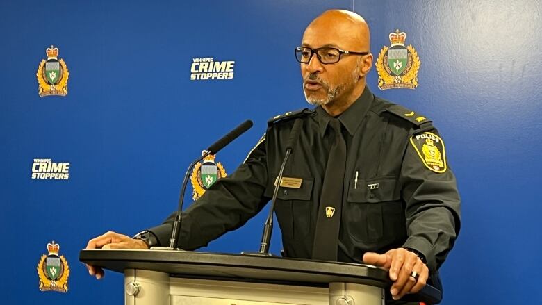 A uniformed police officer speaks at a podium.