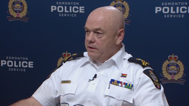 A man in a police uniform is sitting down.