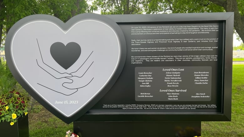 A monument is pictured. It has a heart shape on it with two people holding hands.