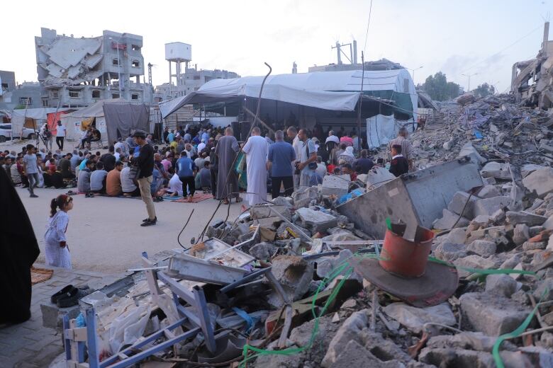 Palestinians gather near the ruins of buildings in Khan Younis in the Gaza Strip.