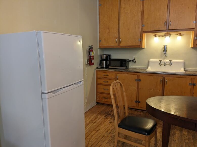 A kitchen with a white fridge and wood cabinets. 